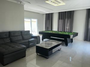 a living room with a pool table and a couch at Ocean Gem in Bakau