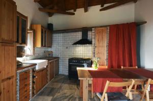 a kitchen with a wooden table and a red curtain at Ilia House Altomira in Altomirá