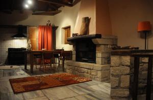 a living room with a stone fireplace and a table at Ilia House Altomira in Altomirá +1 photo