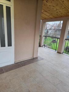 an empty patio with a white door and a fence at Cosy Apartment in Podgorica - Fast WiFi & cable TV in Konik