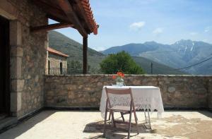 a table and a chair on a balcony with mountains at Ilia House Altomira in Altomirá