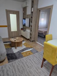 a living room with a couch and a table at Cosy Apartment in Podgorica - Fast WiFi & cable TV in Konik