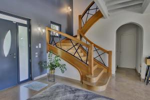 a wooden staircase in a living room with a hallway at Villa d'Exception 330m Piscine 12x6 in Fontaines-Saint-Martin