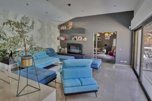 a living room with blue chairs and a fireplace at Villa d'Exception 330m Piscine 12x6 in Fontaines-Saint-Martin