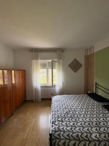 an empty bedroom with a bed and a window at Villa Magnolia Oliveti relax e privacy con panorama mozzafiato in Crosano