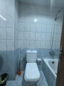 a bathroom with a toilet and a sink and a tub at Ajman Studio Downtown B2OO7 in Ajman 