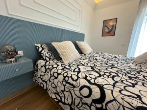 a bedroom with a bed with a black and white comforter at Umbrella Street Home in Catania