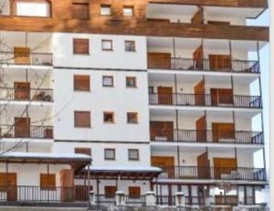 ein hohes weißes Gebäude mit Balkonen in der Unterkunft Piccolo Bric in Ghigo + 2 Fotos