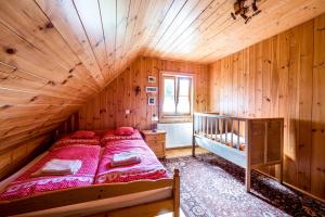 1 dormitorio con 1 cama en una habitación de madera en Chalupa Pod Lomem, en Dolní Morava