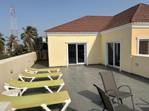 a row of chairs and tables on a patio at Ocean Gem in Bakau