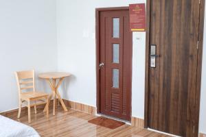 a room with a door and a chair and a table at Khách sạn Cozy Home 2 in Can Tho