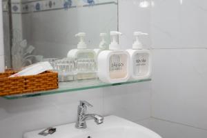 a bathroom with a sink and two soap dispensers on a mirror at Khách sạn Cozy Home 2 in Can Tho +9 photos