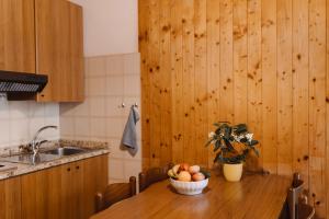 a kitchen with a table with a bowl of fruit on it at Villaggio California in Eraclea Mare +6 photos