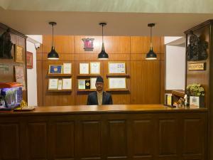a man sitting at a bar in a restaurant at Ambassador Garden Home in Kathmandu