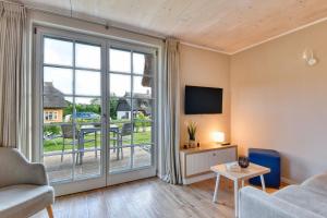 a living room with a couch and a large window at Ferienhaus Boddenlust 24 Feriendorf Klein Stresow Rügen by ruyastay in Putbus