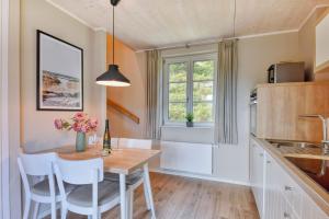 a kitchen with a table and chairs and a window at Ferienhaus Boddenlust 24 Feriendorf Klein Stresow Rügen by ruyastay in Putbus