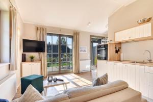 a kitchen and living room with a couch and a table at Ferienhaus Strandbude Feriendorf 32 Klein Stresow Rügen by ruyastay in Putbus