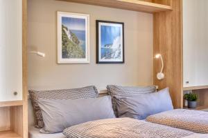 a bedroom with two beds and three pictures on the wall at Ferienhaus Strandbude Feriendorf 32 Klein Stresow Rügen by ruyastay in Putbus