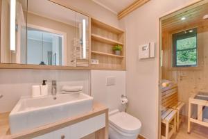 a bathroom with a sink and a toilet at Ferienhaus Strandbude Feriendorf 32 Klein Stresow Rügen by ruyastay in Putbus +5 photos