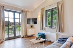 a living room with a couch and a tv at Ferienhaus Lotta Feriendorf 29 Klein Stresow Rügen by ruyastay in Putbus