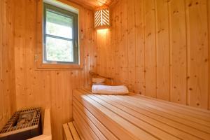 a wooden cabin with a bed and a window at Ferienhaus Lotta Feriendorf 29 Klein Stresow Rügen by ruyastay in Putbus