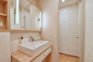a white bathroom with a sink and a shower at Ferienhaus Lotta Feriendorf 29 Klein Stresow Rügen by ruyastay in Putbus +6 photos