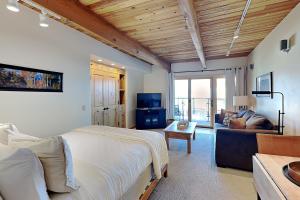 a bedroom with a large bed and a living room at Timberline Condominiums Studio Deluxe Unit 215 in Snowmass Village