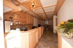 a large kitchen with wooden cabinets and a table at B&B Ledro AFFITTACAMERE in Mezzolago +19 photos