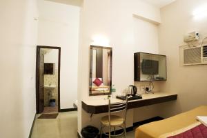 a room with a vanity with a mirror and a sink at Hotel BMR Stay in Pollāchi