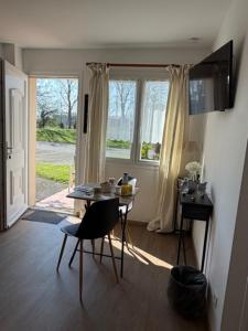 a room with a table and chairs and a window at L'Overlord , meublé de tourisme in Colleville-sur-Mer