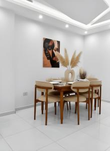 a dining room with a table and chairs and a painting at pyramids view luxury apartment in ‘Ezbet `Abd el-Ḥamîd +2 photos