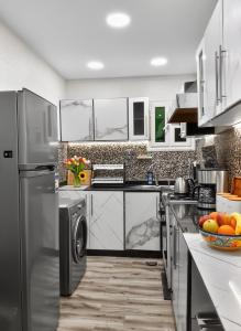 a kitchen with a stainless steel refrigerator and a dishwasher at pyramids view luxury apartment in ‘Ezbet `Abd el-Ḥamîd