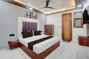 a bedroom with a large bed and a television at Townhouse Tuessday Suites Nearst Mr Bhatura Bala Sector 122 in Noida +22 photos