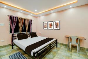 a bedroom with a bed and a table and a chair at SPOT ON RISA PALACE in Bhutiāgāon