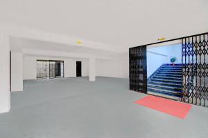 an empty room with a large glass wall with stairs at SPOT ON RISA PALACE in Bhutiāgāon