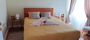 a bedroom with two swans towels on a bed at Casa do Faial da Terra in Faial da Terra