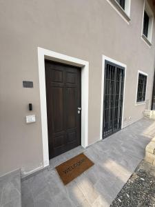 a brown door on a white building with two gates at NessunConfine Casa Laura in Santa Giuletta