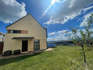 a white house with the sun in the sky at Studio or Panoramic Villa with hydro tube extracost in Cluj-Napoca