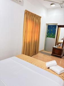 a bedroom with a large bed and a window at Aloe Serene in Negombo