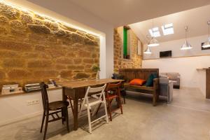 ein Esszimmer mit einer Steinmauer sowie einem Tisch und Stühlen in der Unterkunft Casa la Devesa de Sanabria in Remesal