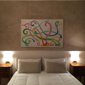 a bedroom with a bed with a painting above it at Al Cavallino in Follina