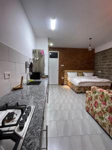 a hotel room with a bed and a kitchen with a stove at Jabulani Moshi in Msaranga