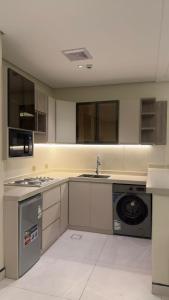 an empty kitchen with a sink and a dishwasher at شاليهات الحدبان - Al Hadban Chalets in Ash Shafa