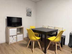 a dining room with a table and yellow chairs at Siente Riaño in Riaño