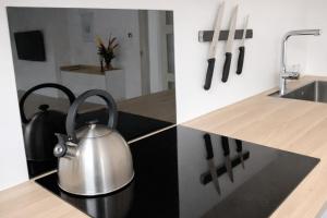 a stainless steel tea kettle on a kitchen counter at Rogvi's new appartment in Klaksvík
