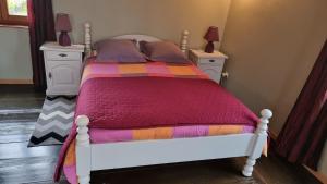 a bedroom with a white bed with a colorful blanket at La Gloriette Riquewihr in Riquewihr