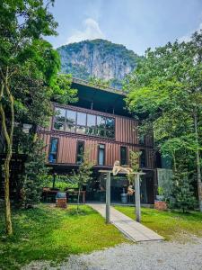 a house with a mountain in the background at Templer Park Rainforest Retreat TPRR in Rawang