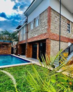a house with a swimming pool in front of it at Jabulani Moshi in Msaranga