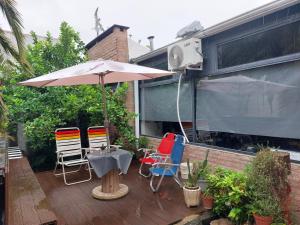 a patio with a table and chairs and an umbrella at Loft Salta in Bahía Blanca