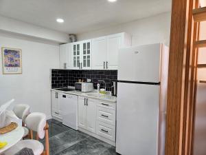 a kitchen with white cabinets and a white refrigerator at Sapancamodern 2 in Sapanca